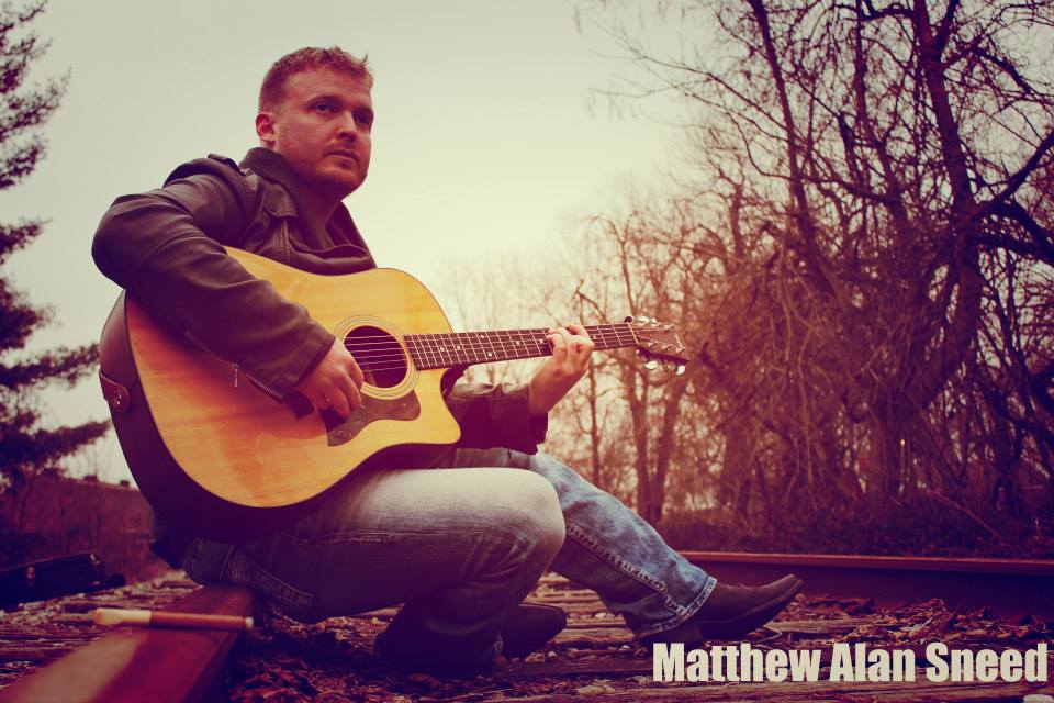 Image of Matthew Alan Sneed playing guitar, from music cover featured in article.