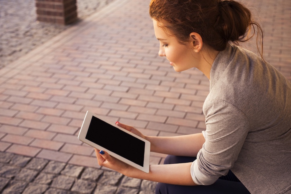 Woman viewing device and contemplating options, making choice