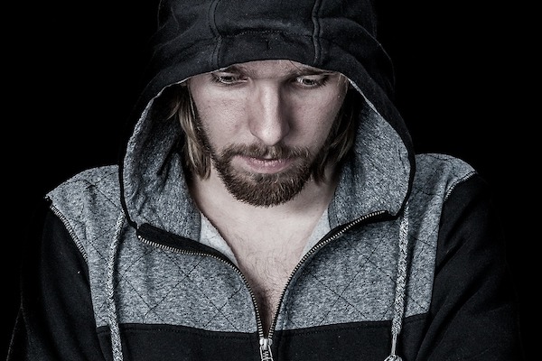 Man set against dark backdrop looking down